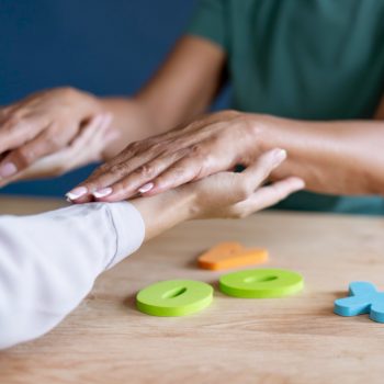 Profissional realiza terapia com as mãos sobre os braços de uma pessoa, em ambiente calmo, representando uma prática de medicina integrativa voltada ao bem-estar e à conexão corpo-mente.