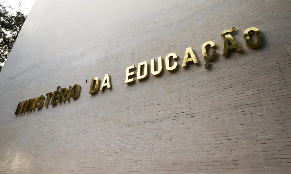 Fachada do prédio do Ministério da Educação (MEC), com a inscrição “Ministério da Educação” em letras douradas sobre parede clara.