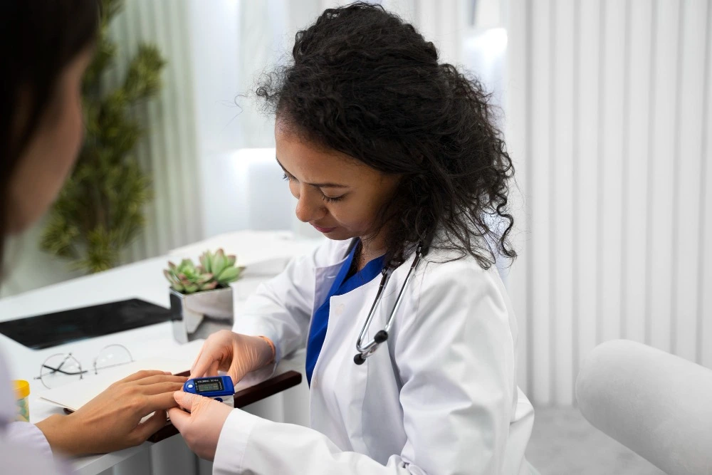 Profissional de saúde medindo a saturação de oxigênio no dedo de uma paciente durante uma consulta.